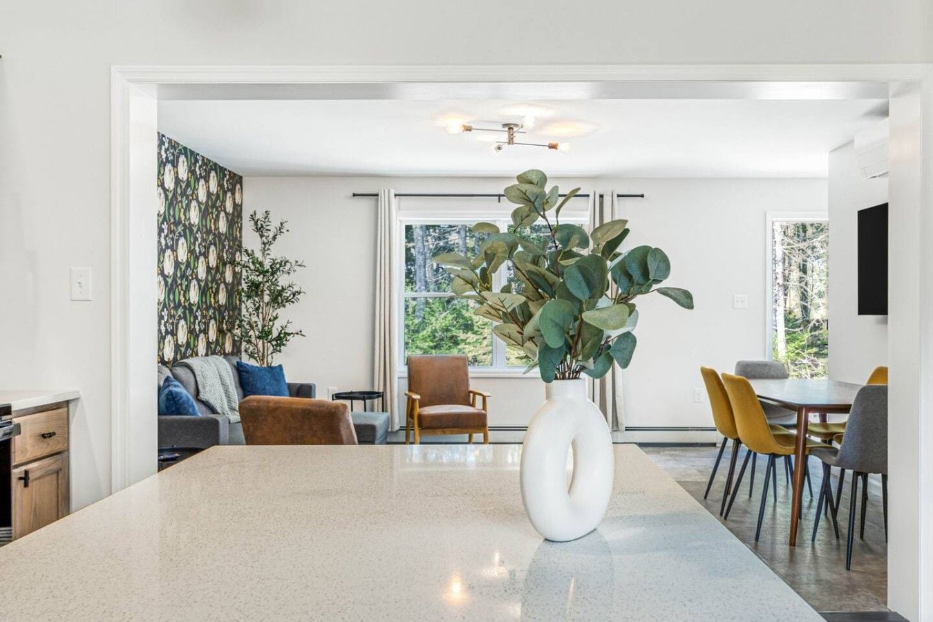 A modern interior with a kitchen island, dining area, and seating.