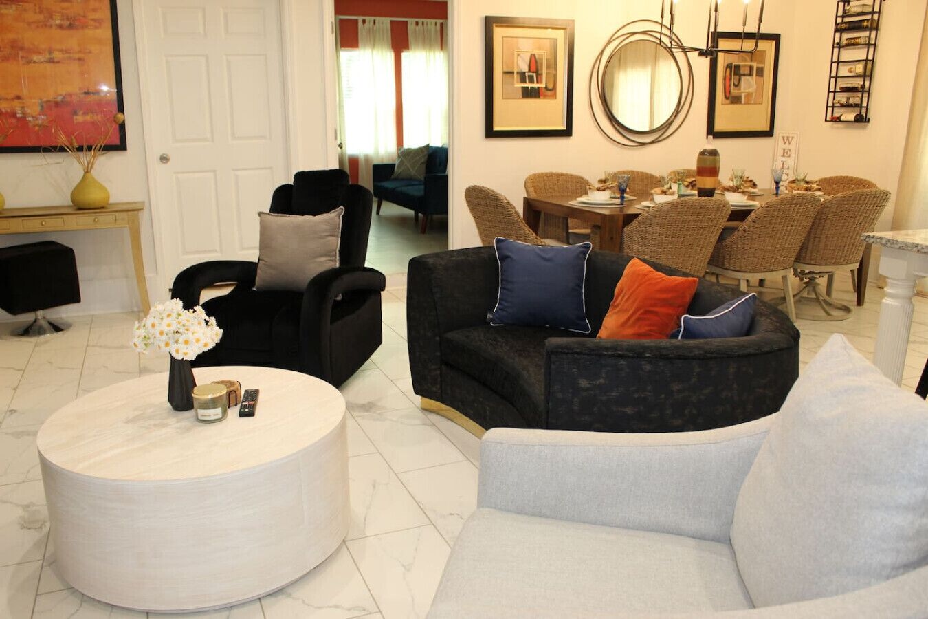 Un salon comprenant un canapé, des fauteuils, une table basse et un coin repas avec une table et des chaises.