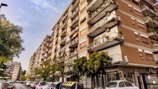 A multi-story residential building with balconies, parked cars, and a clear sky. - Close Cinecittà studios suitable for families and pets Metro 5 minutes walking (Roma)