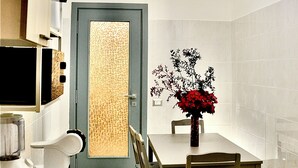 A modern kitchen with a dining area, featuring a patterned backsplash, a central island, and a chandelier. - Close Cinecittà studios suitable for families and pets Metro 5 minutes walking (Roma)