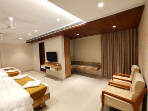 A hotel room with two beds, a TV, a wooden bench, and a window with curtains. - THE PARADISE KINGDOM (Kanchipuram)