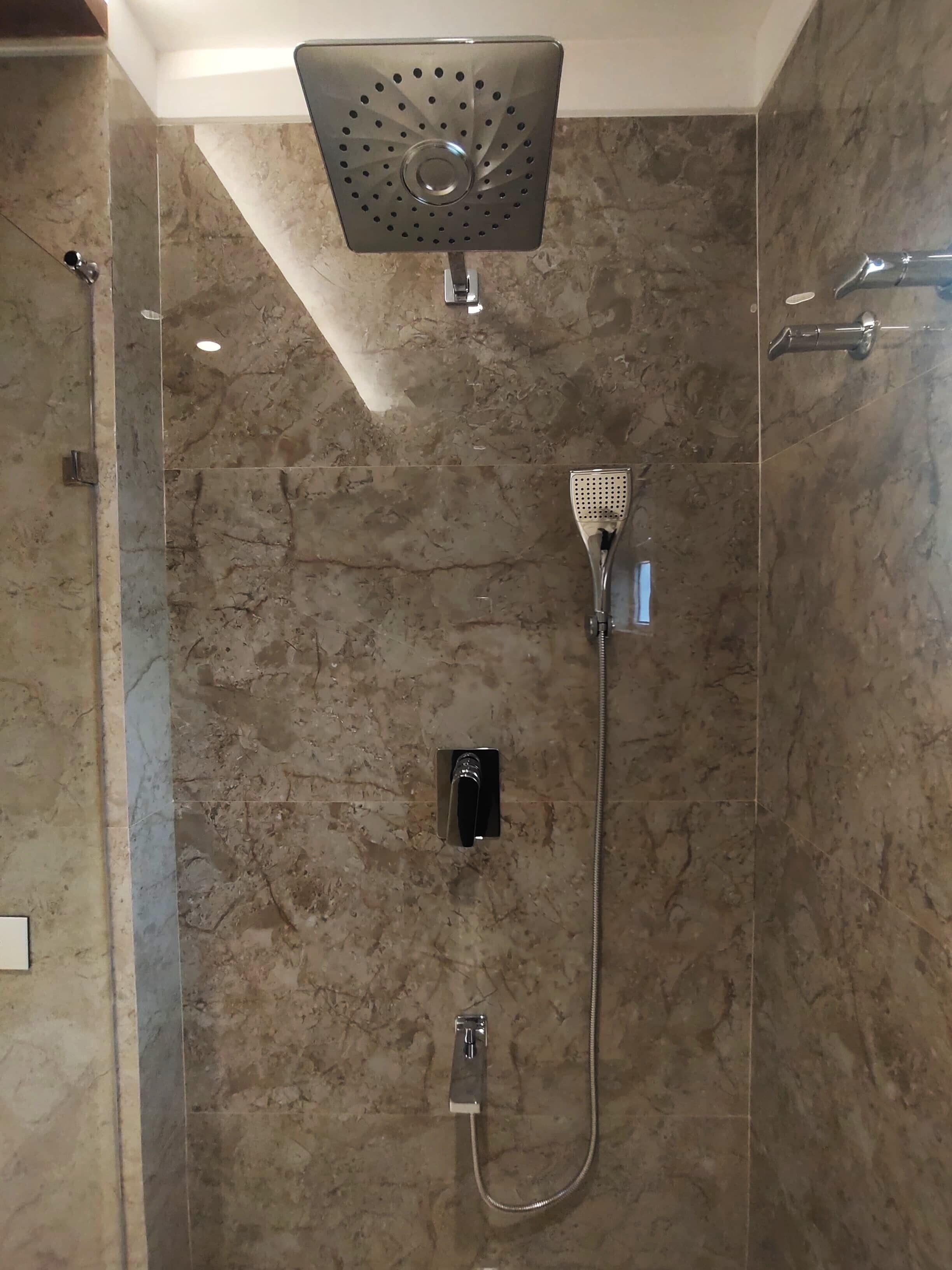 Eine moderne Dusche mit Duschkopf, Handbrause und einer fest montierten Bedienkonsole.