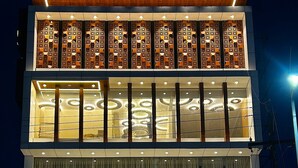 A multi-story building with a sign for "The Paradise Kingdom Luxury Stay" and "Saisanget Veg". - THE PARADISE KINGDOM (Kanchipuram)