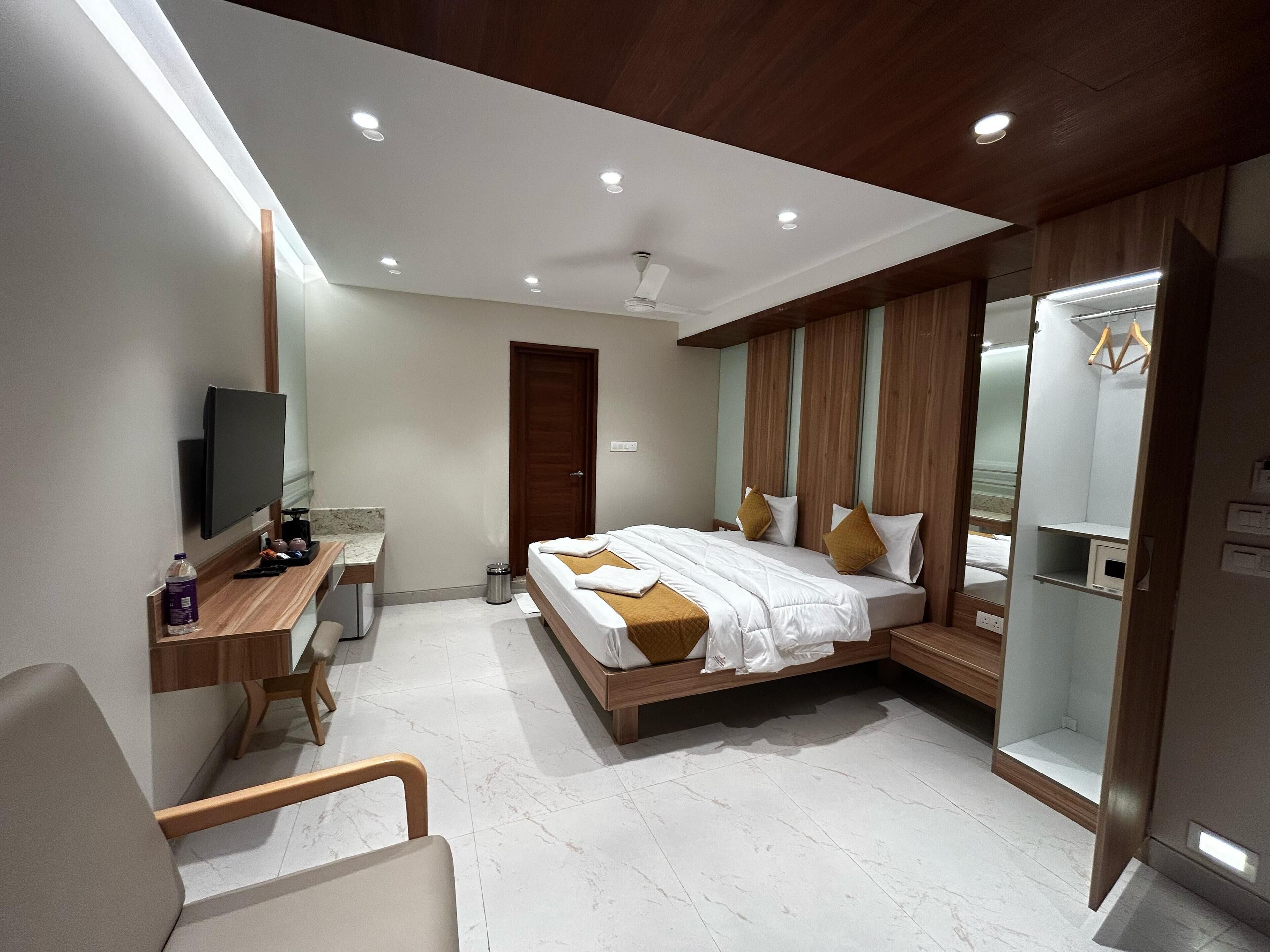Ein modernes Hotelzimmer mit Bett, Schreibtisch, Fernseher und Kleiderschrank.