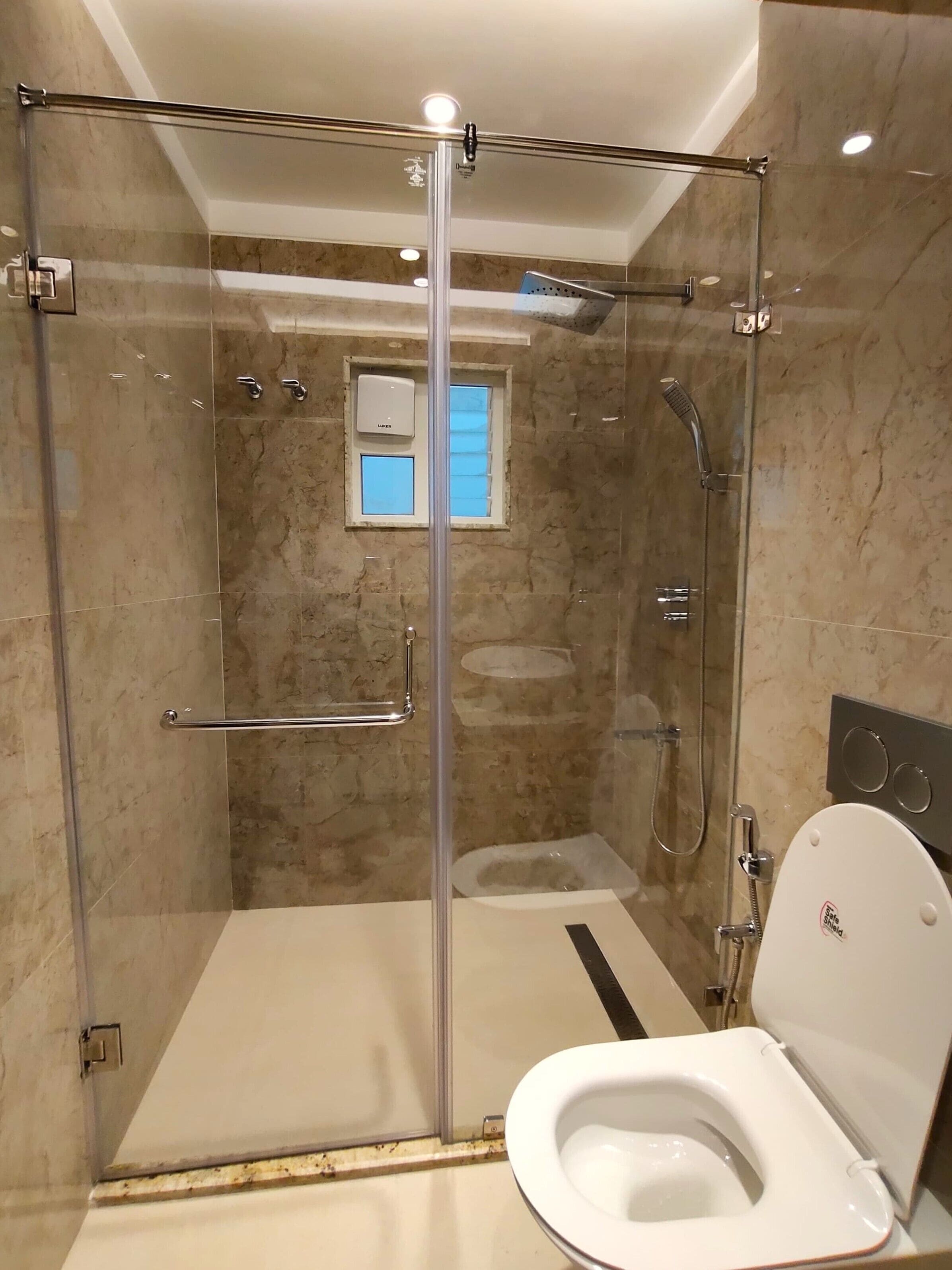 A modern bathroom with a glass-enclosed shower, a toilet, and a bathtub.
