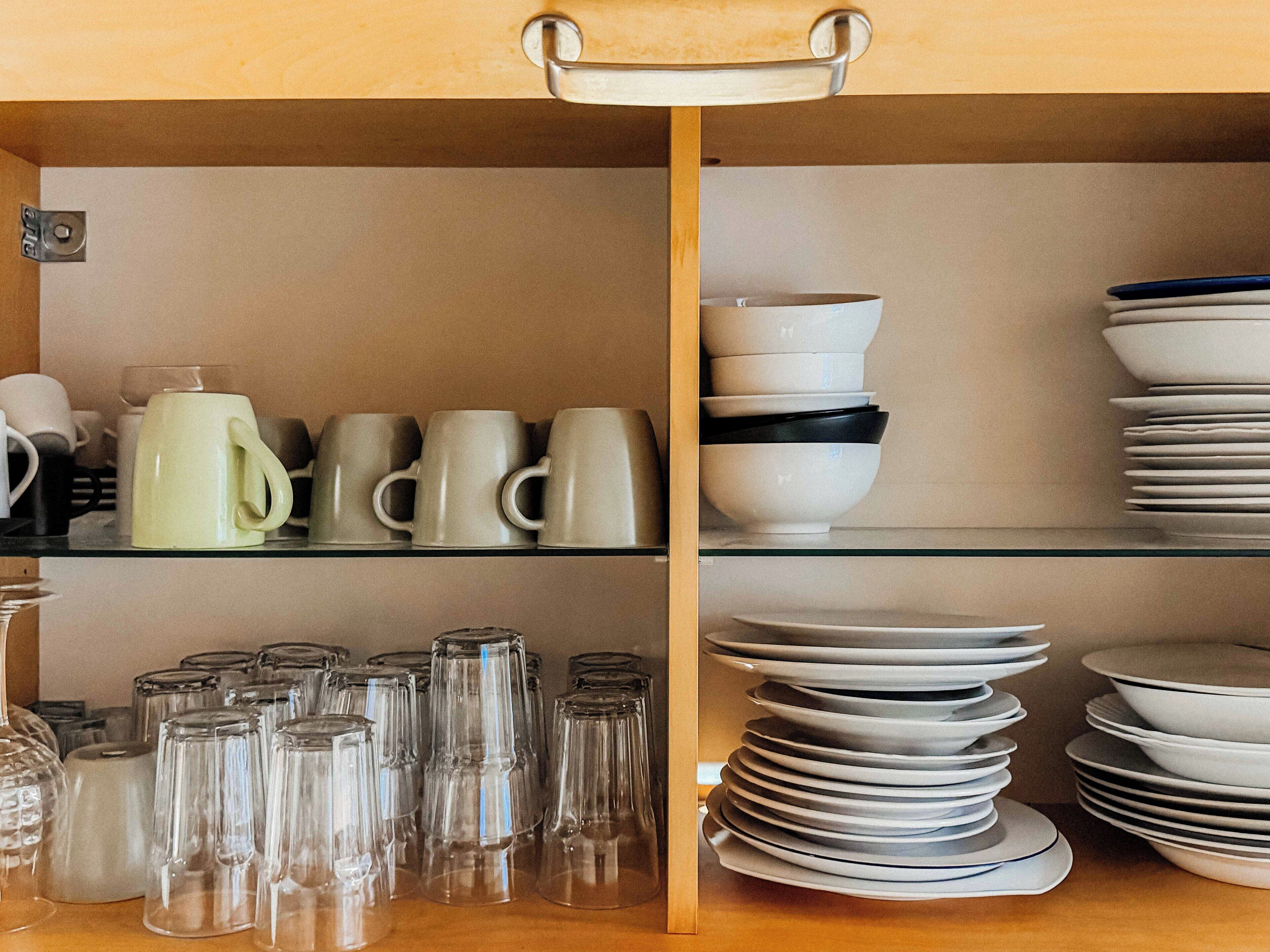 A kitchen with shelves holding various glassware and dishes.