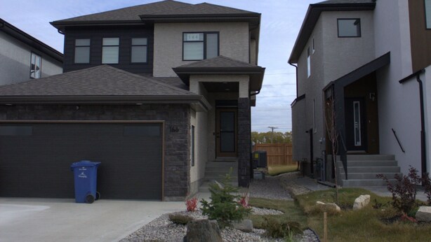 Un quartier résidentiel avec des maisons modernes, une allée et une pelouse bien entretenue.