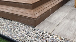Une terrasse en bois avec des marches menant à l’entrée de la maison.