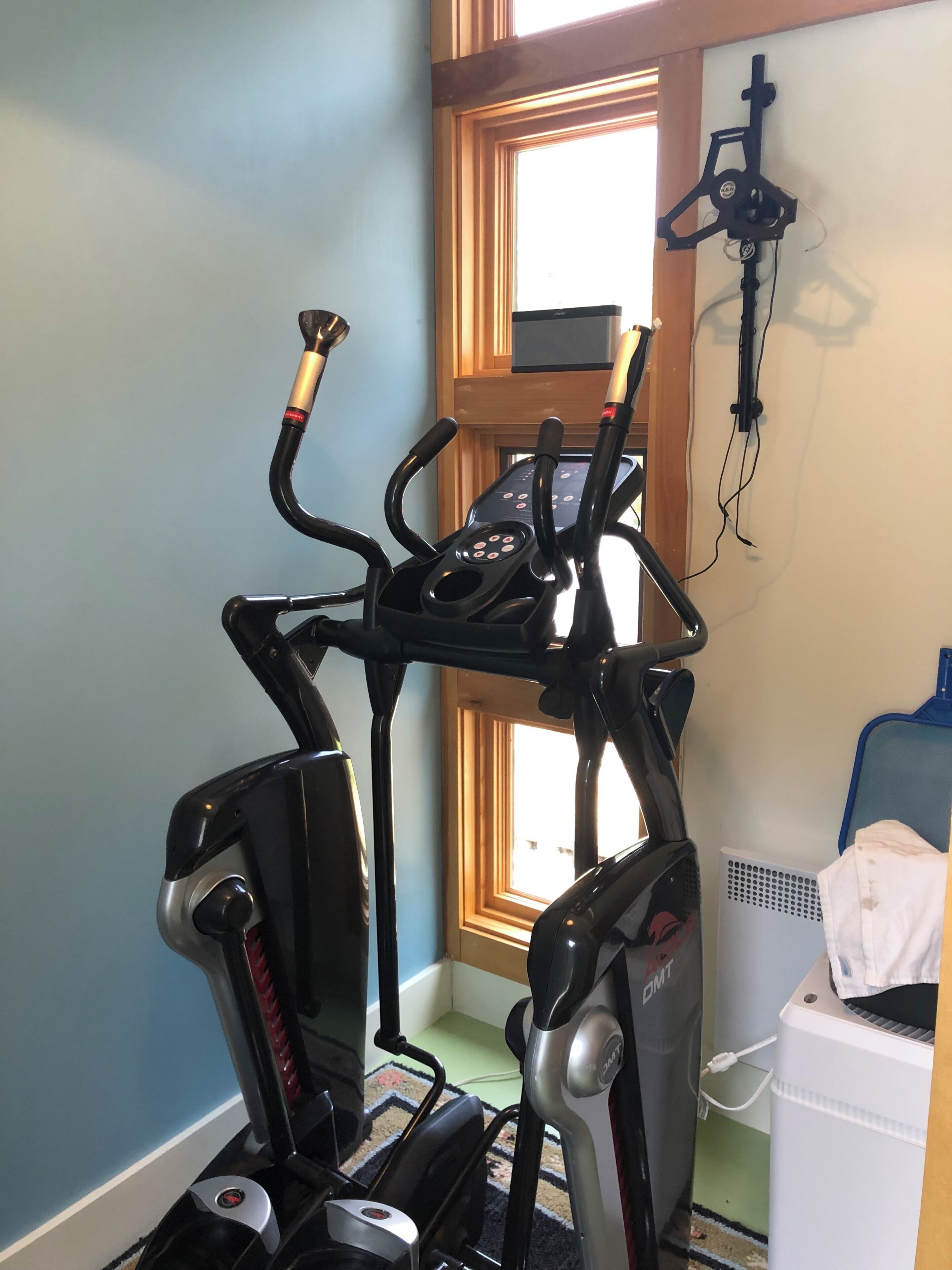 Une salle de sport à domicile équipée d’un vélo elliptique, d’un vélo d’appartement et d’un tapis de course.