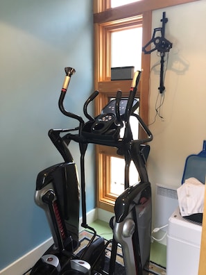 A home gym with an elliptical, a stationary bike, and a treadmill. - Cozy In Town Manchester Studio w/ Loft Bedroom. (Manchester)