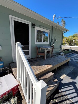 A house with a porch, a window, and a door. - Charming studio with large outdoor patio. Fully fenced and pets are welcome! (St. Petersburg)