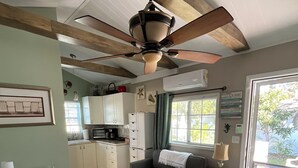 A cozy room with a bed, a desk, a sofa, and a kitchenette. - Charming studio with large outdoor patio.  Fully fenced and pets are welcome! (St. Petersburg)