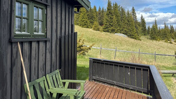 A wooden building with a deck, a bench, and a view of a forested hillside. - Cozy cabin with a spectacular view! Pet-friendly - 15 minutes to skiing resort! (Buskerud)