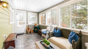 A cozy room with a fireplace, a sofa with blue cushions, and a wooden bench. - FAMILY-FRIENDLY, King Bed, Outdoor Space, Pet-Welcome - Intervale Lodge (Intervale)