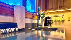 A kitchen with a stainless steel sink, a towel dispenser, and a coffee machine. - Bring the dog-colorful SacoRiver (Bartlett)