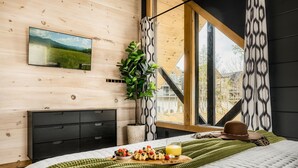 A bedroom with a bed, breakfast tray, and a TV on the wall. - Lux Home-2 Master Suites-Heated Pool-Dollywood 5mi (Pigeon Forge)