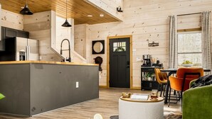 A spacious living area with a wooden interior, a dining table, and a large window. - Lux Home-2 Master Suites-Heated Pool-Dollywood 5mi (Pigeon Forge)