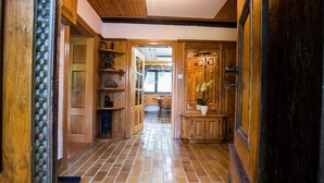 A wooden hallway with tiled flooring, wooden cabinets, and a door leading to a room. - Rustic Authentic Holiday Home with Terrace and Wood Stove - Three Bedroom Holiday Home with Terrace (Ljubno ob Savinji)
