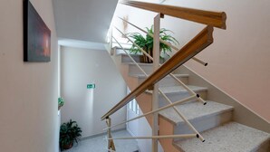 A staircase with a wooden handrail and beige carpeted steps. - Apartments Tafra - One Bedroom Apartment (Lokva Rogoznica)