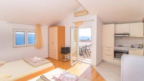 Quarto com duas camas, uma cozinha compacta e varanda com vista.