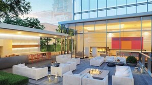 A modern outdoor lounge area with seating and a fire feature.