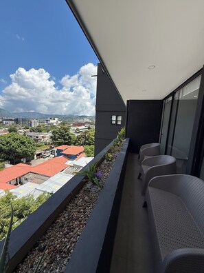 A balcony with a view of a cityscape, including buildings and a mountain. - Apartment Escalon. 3 beds & 2 Sofa beds, WIFI, 2 car parking, AC in all bedrooms (San Salvador)