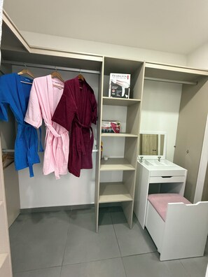 Un vestidor con perchero, estanterías y tocador.