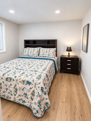A bedroom with a bed, bedside table, lamp, and a window with blinds. - Cozy house in charming Anchorage with WiFi access (Anchorage)