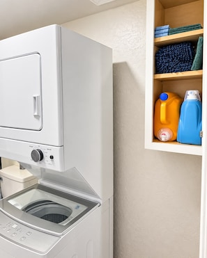 A front-loading washing machine with a control panel and a built-in water tank.