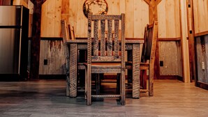 A wooden interior with a staircase, a dining table with chairs, and a refrigerator. - Modern-Rustic, Secluded Cabin w/ Clarion River Frontage, Borders National Forest (Sigel)