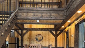 A rustic interior with a wooden staircase, a dining area with a wooden table and chairs, and a 'Hearts Content' rug. - Modern-Rustic, Secluded Cabin w/ Clarion River Frontage, Borders National Forest (Sigel)