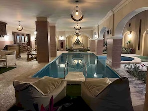 Ein Poolbereich mit Liegestühlen, einer Bar und einer Springbrunnen.
