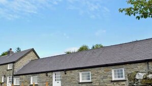 A stone building with a flat roof and multiple windows.