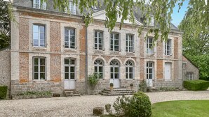 A large, historic building with multiple windows and a gravel driveway. - Lovely home in Ingouville sur Mer (Ingouville sur Mer)