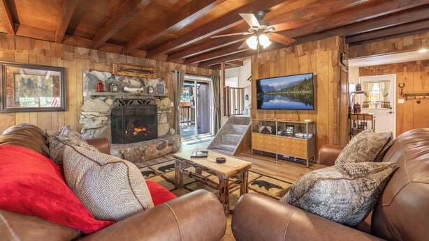 A cozy living room with a fireplace, leather sofas, and a television.