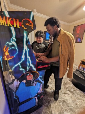 A person standing next to a wall-mounted poster with a character and lightning effects.