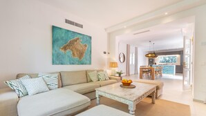 A modern living room with a sofa, coffee table, and a painting on the wall. - Beautiful home in Canyamel with private swimming pool, can be inside or outside (Canyamel)