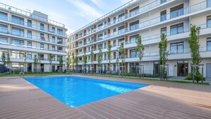 A modern apartment building with a central swimming pool, multiple balconies, and a well-maintained garden area. - Amazing apartment in Ustronie Morskie (Ustronie Morskie)
