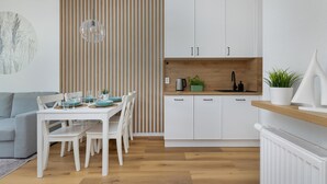 A modern kitchen with white cabinets, a wooden countertop, and a built-in sink. - Amazing apartment in Ustronie Morskie (Ustronie Morskie)