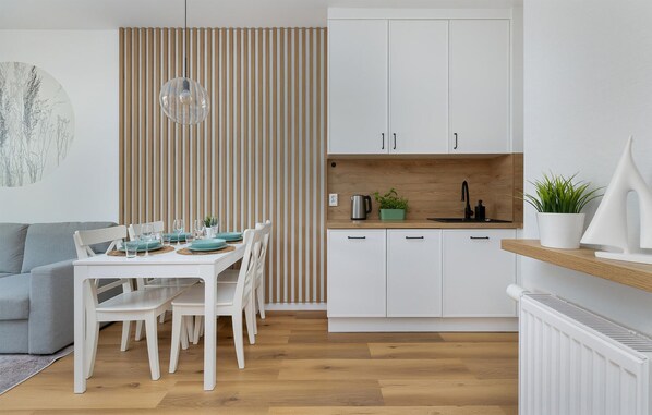 A modern kitchen with white cabinets, a wooden countertop, and a built-in sink.