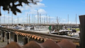 A marina with multiple boats docked, a clear sky, and a distant view of land. - 3 bedroom awesome home in Marstal (Marstal)
