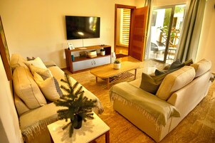 Apartamento Deluxe, vistas al jardín | Zona de estar | Una televisión de pantalla plana