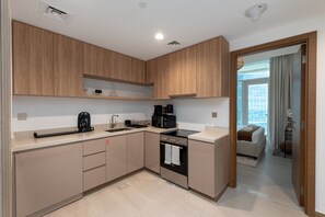 A modern kitchen with wooden cabinets, a built-in oven, and a coffee maker.
