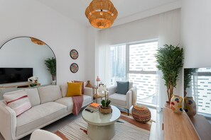 A modern living room with a sofa, coffee table, and decorative plants.
