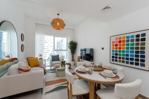 A modern living room with a sofa, coffee table, and dining table set for a meal.