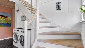 Una escalera con escalones de madera y una pared blanca.