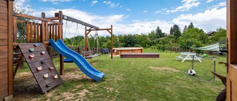 A playground with a slide, swings, and climbing structures.