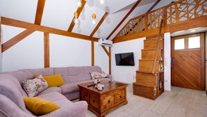A living room with a sofa, wooden coffee table, and a staircase with a wooden railing. - Cozy home in Klostar Ivanic with sauna (Klostar Ivanic)