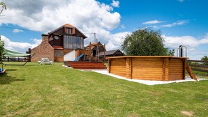 A wooden cabin with a slide, a wooden deck, and a fenced area. - Cozy home in Klostar Ivanic with sauna (Klostar Ivanic)