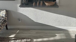 Una cocina moderna con armarios oscuros, un microondas empotrado y una pequeña isla con un lavamanos.